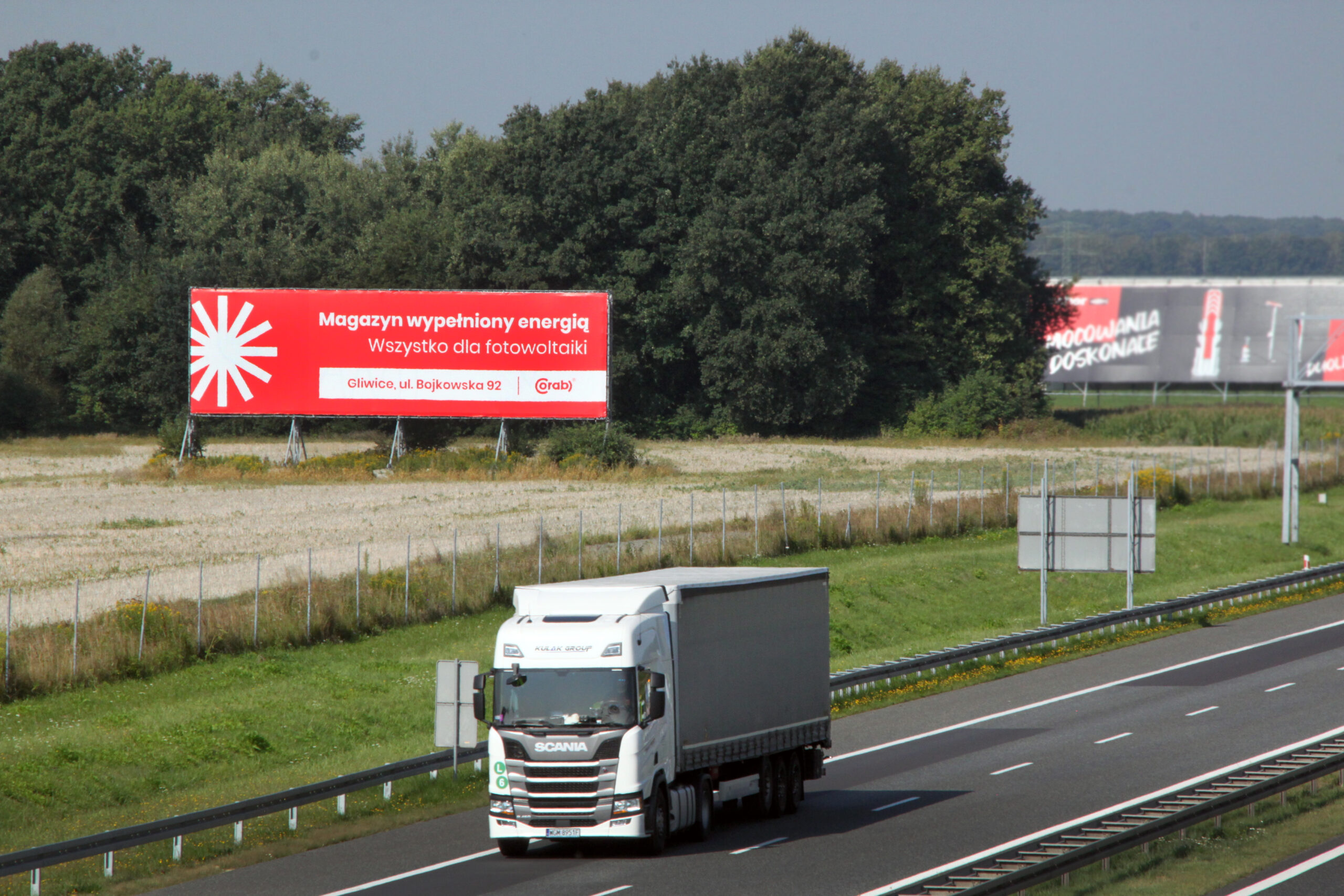 Megaboard przy autostradzie z przejeżdżającą ciężarówką